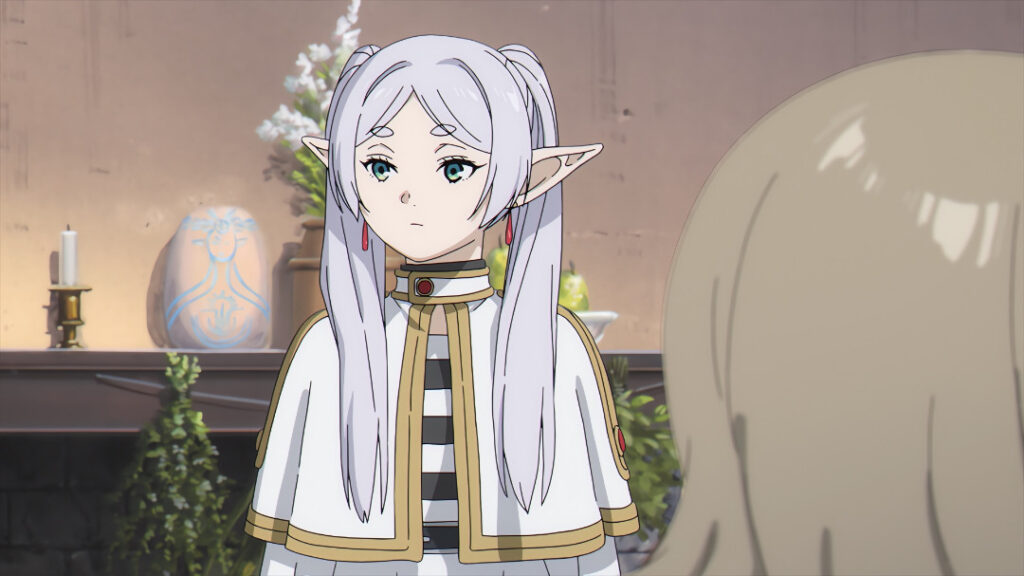 Behing Frieren in a house altar, candles, a stone with the figure of the goddess and some flowers and fruits as offerings appear. 